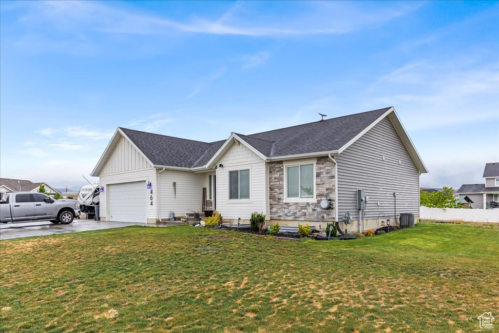 Ranch-style home with a garage, driveway, roof with shingles, and stone siding