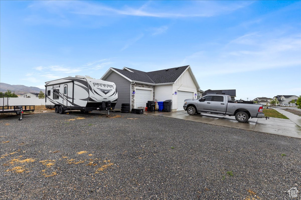 View of property exterior featuring a garage, board and batten siding, and driveway