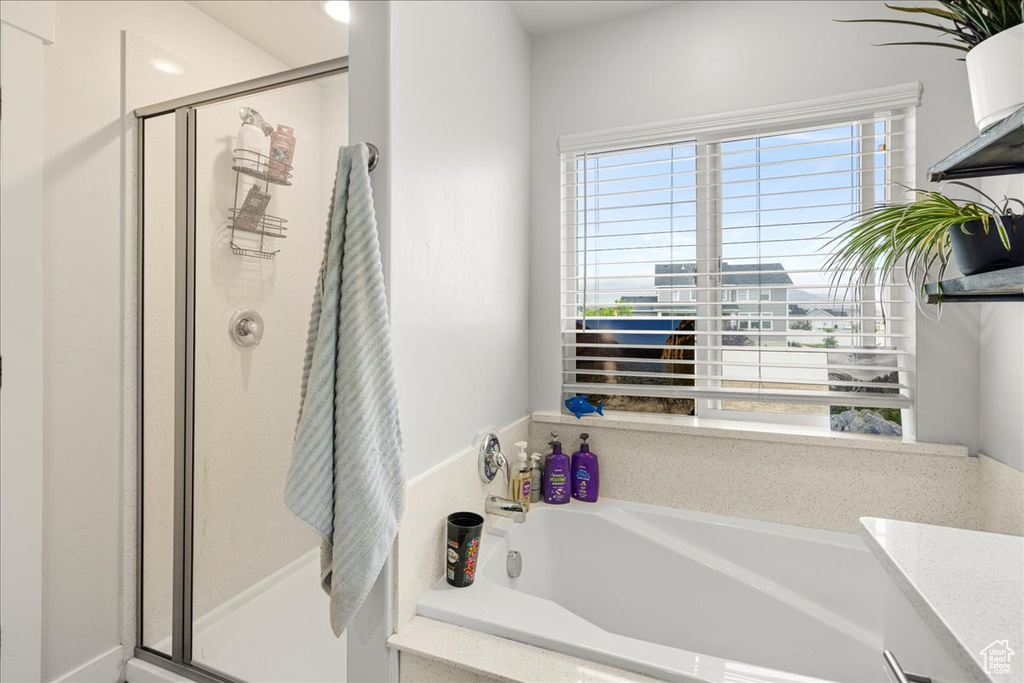 Bathroom with a shower stall and a bath