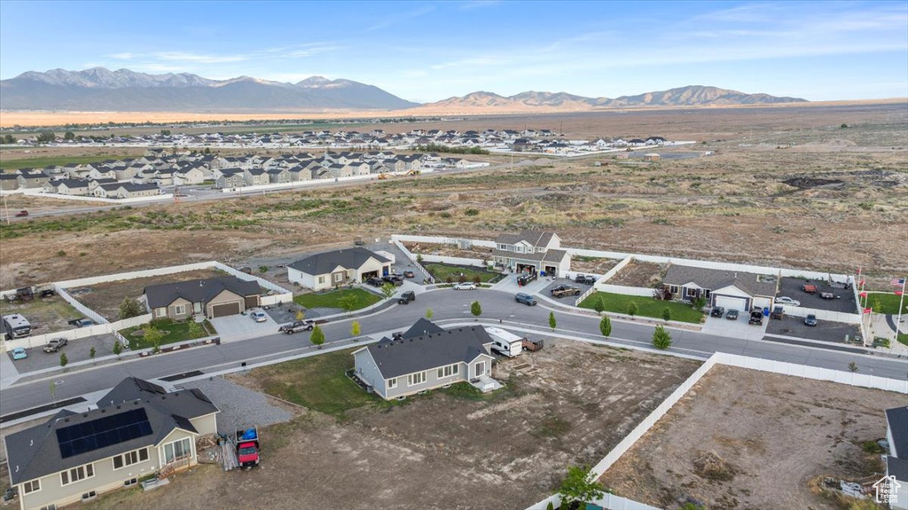 Aerial view of residential area featuring a mountainous background and a desert landscape