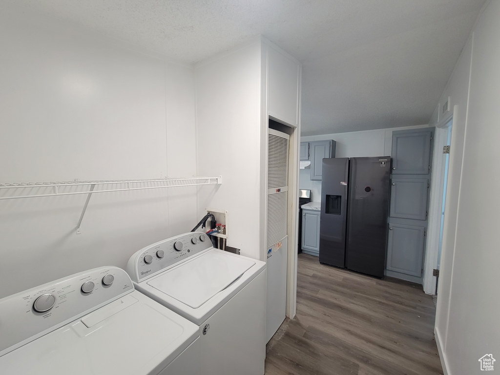 Laundry room featuring wood finished floors and washing machine and dryer