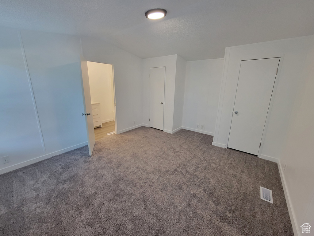 Unfurnished bedroom with carpet floors and baseboards