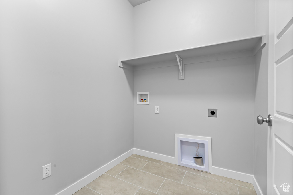 Washroom featuring hookup for an electric dryer, washer hookup, baseboards, and light tile patterned floors