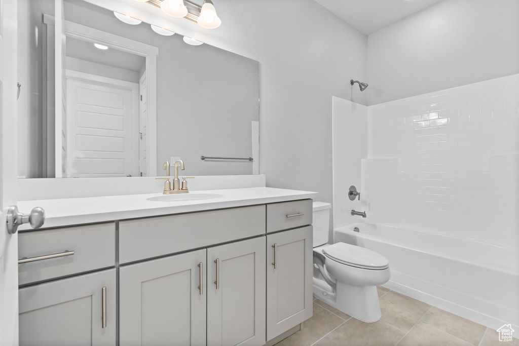 Bathroom featuring vanity, shower / washtub combination, tile patterned floors, and toilet