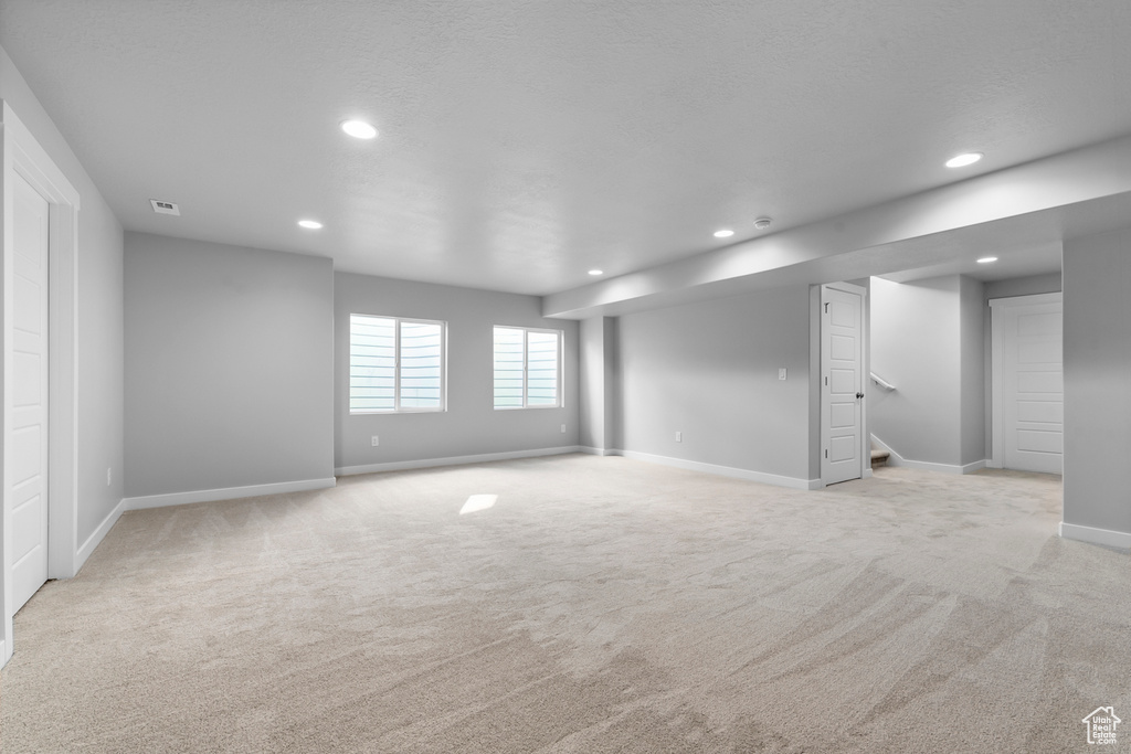Spare room featuring recessed lighting, baseboards, and light carpet