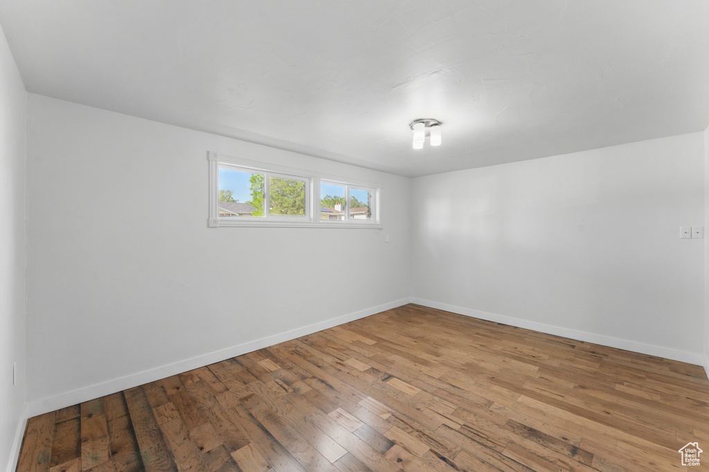 Empty room with baseboards and hardwood / wood-style floors