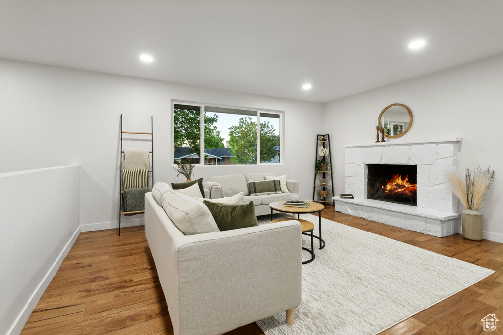 Living area with a premium fireplace, wood finished floors, recessed lighting, and baseboards
