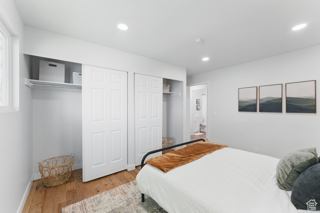 Bedroom featuring multiple closets, wood finished floors, recessed lighting, and baseboards