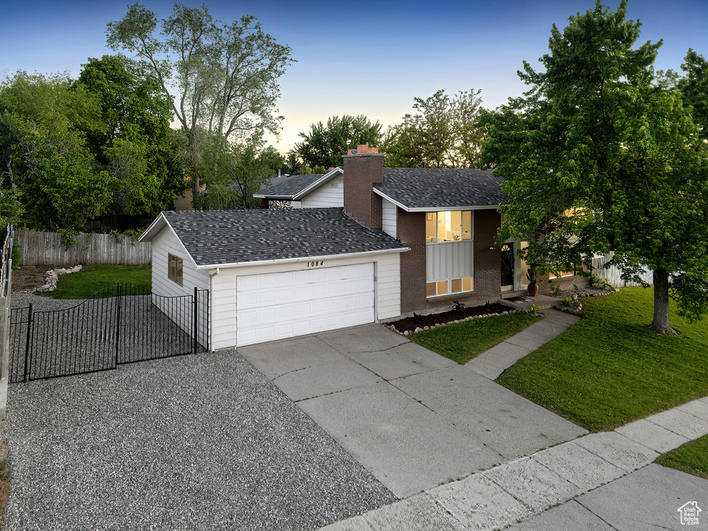 View of front of home with an attached garage, driveway, roof with shingles, and brick siding