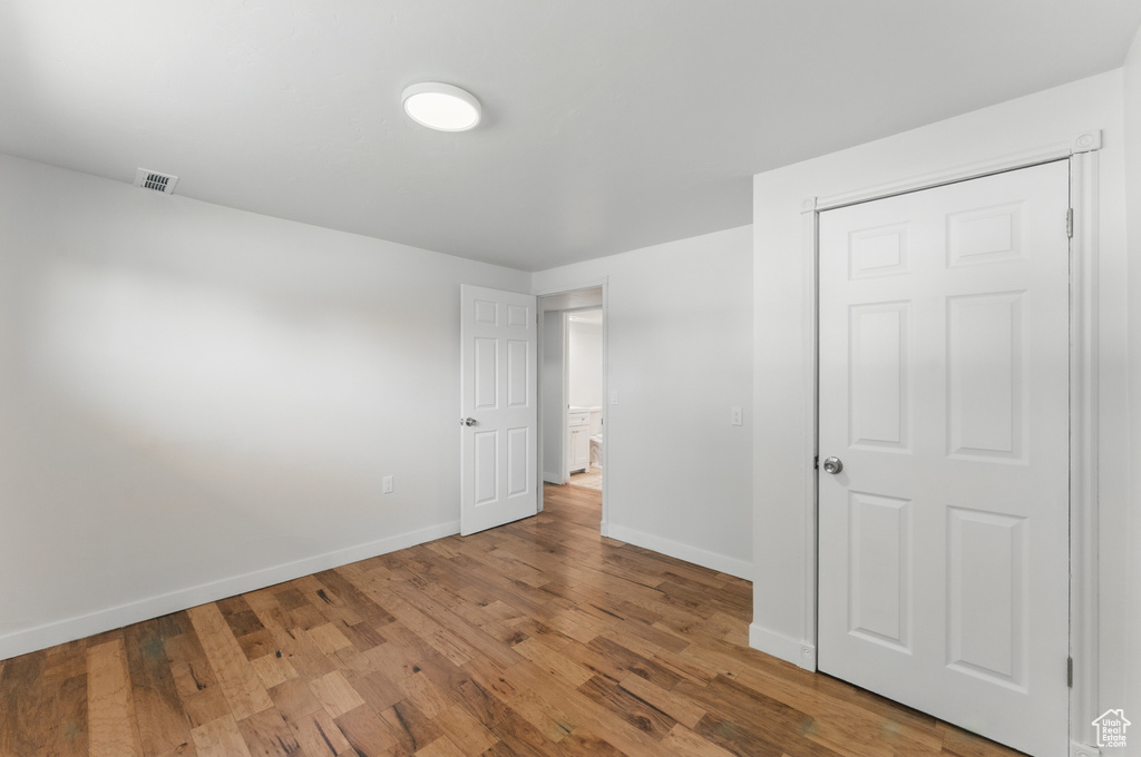 Unfurnished bedroom with wood finished floors and baseboards