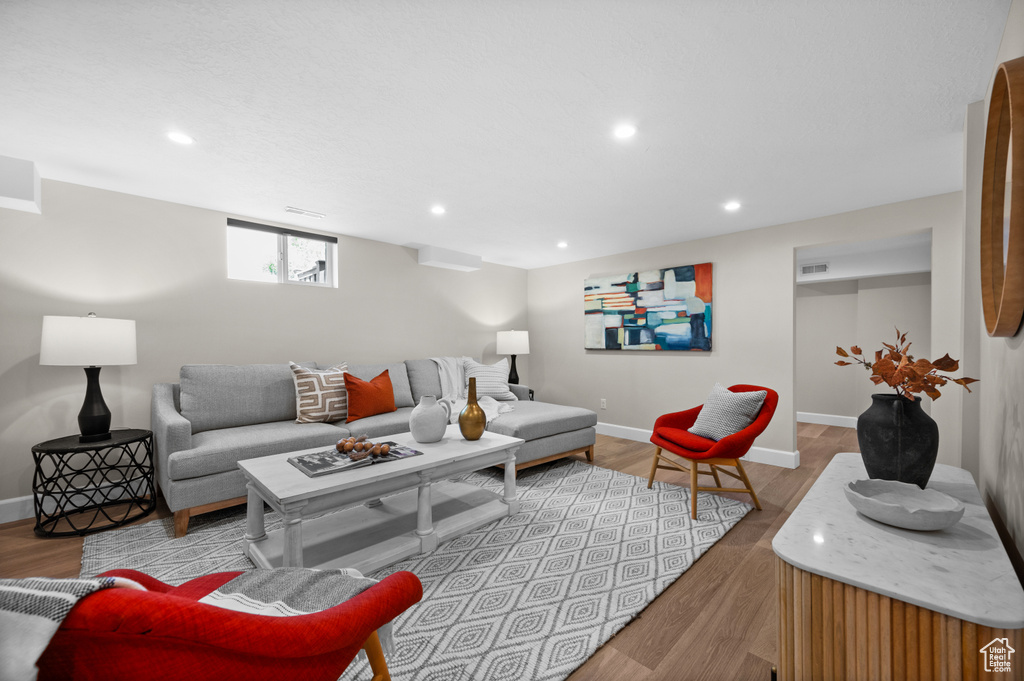 Living area with wood finished floors, recessed lighting, and baseboards