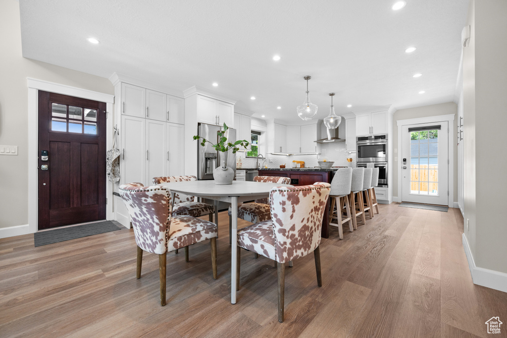 Dining room featuring light wood finished floors, recessed lighting, and baseboards