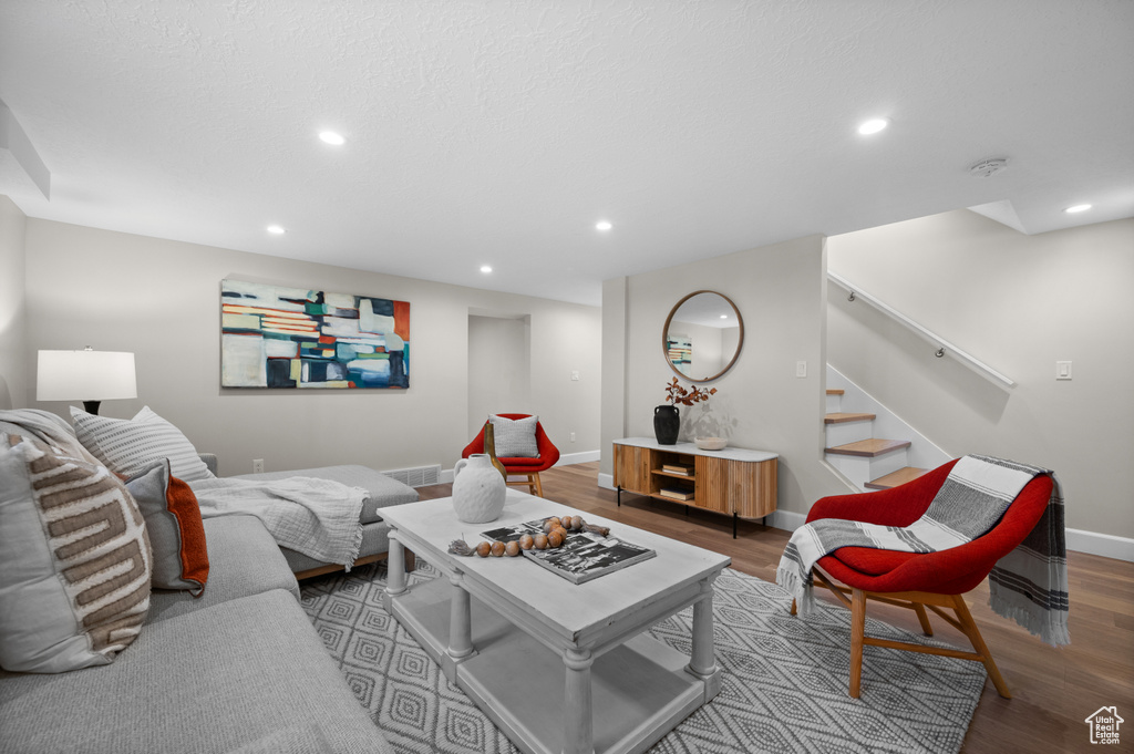 Living area featuring wood finished floors, recessed lighting, baseboards, and stairs