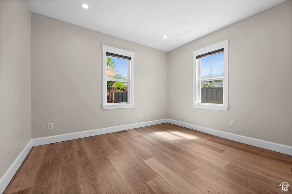 Unfurnished room with light wood-style floors, baseboards, and recessed lighting