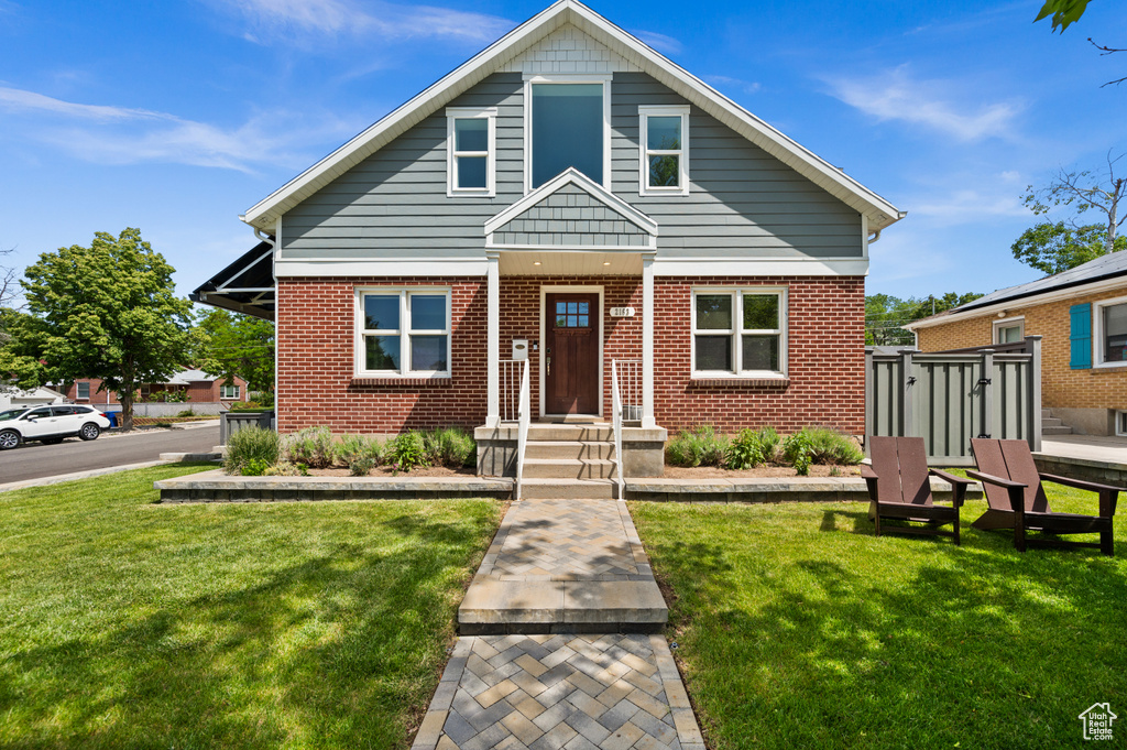 View of front facade with brick siding and a front yard