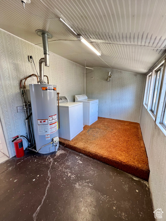 Below grade area with gas water heater, wallpapered walls, and washer and clothes dryer