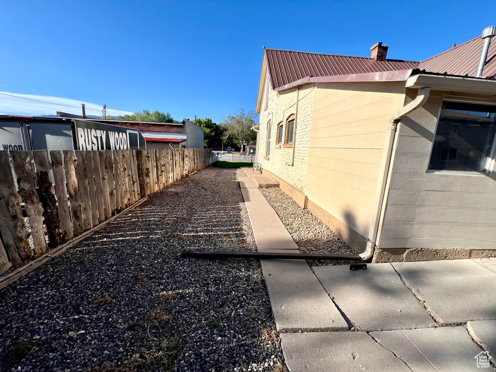 View of side of property with metal roof and a chimney