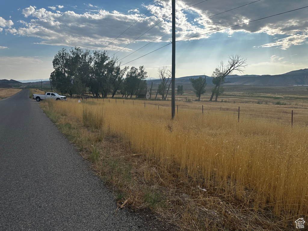 View of asphalt street with a view of countryside and a mountain view