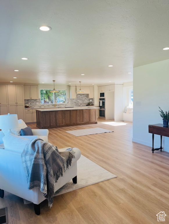 Living room featuring light wood finished floors and recessed lighting