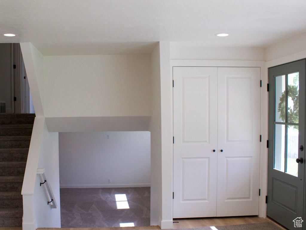 Foyer entrance featuring wood finished floors, stairway, recessed lighting, and baseboards
