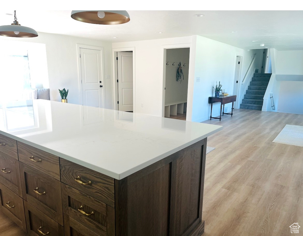 Kitchen featuring light wood-style floors, light countertops, dark brown cabinetry, and recessed lighting