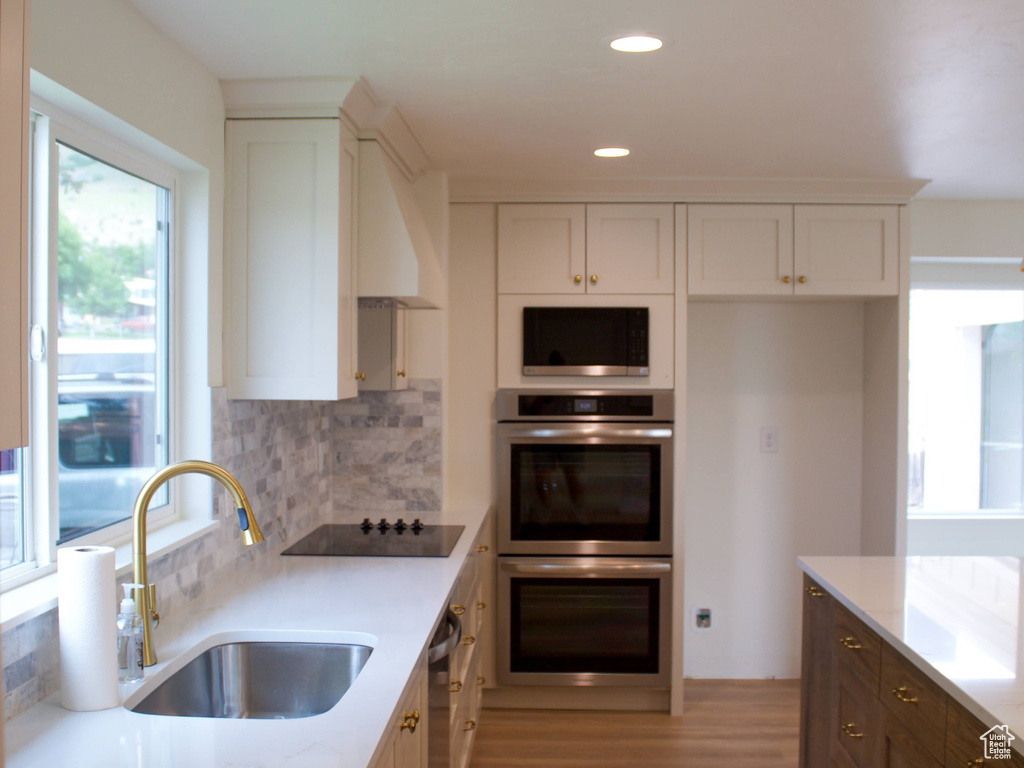 Kitchen featuring a sink, white cabinets, appliances with stainless steel finishes, and recessed lighting