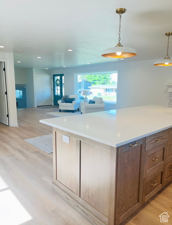 Kitchen with healthy amount of natural light, pendant lighting, light countertops, and recessed lighting