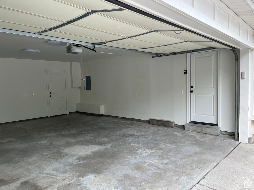 Garage featuring electric panel and a garage door opener