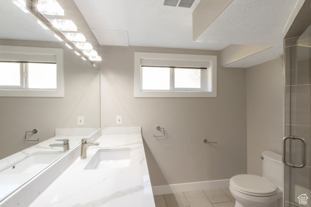 Full bath featuring toilet, baseboards, vanity, an enclosed shower, and tile patterned flooring
