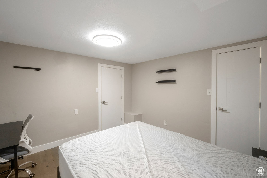 Bedroom featuring wood finished floors and baseboards