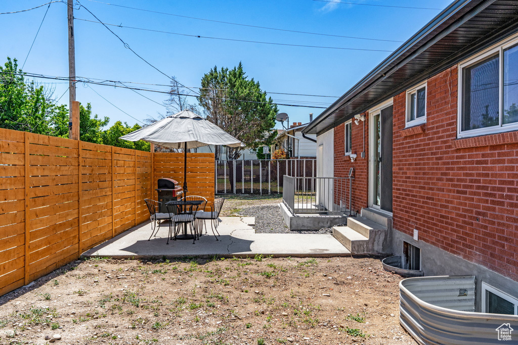 Fenced backyard featuring a patio area and entry steps