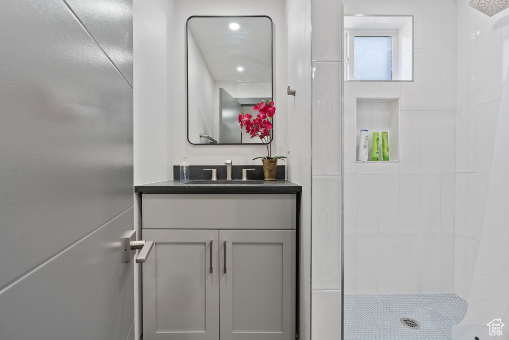 Bathroom with tiled shower and vanity