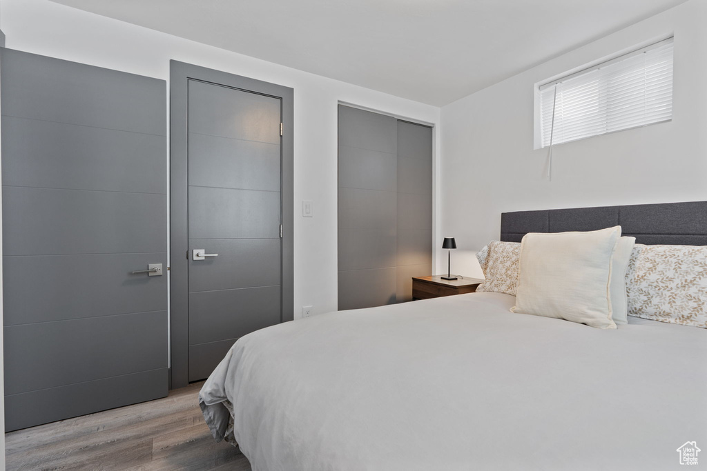 Bedroom with wood finished floors and a closet