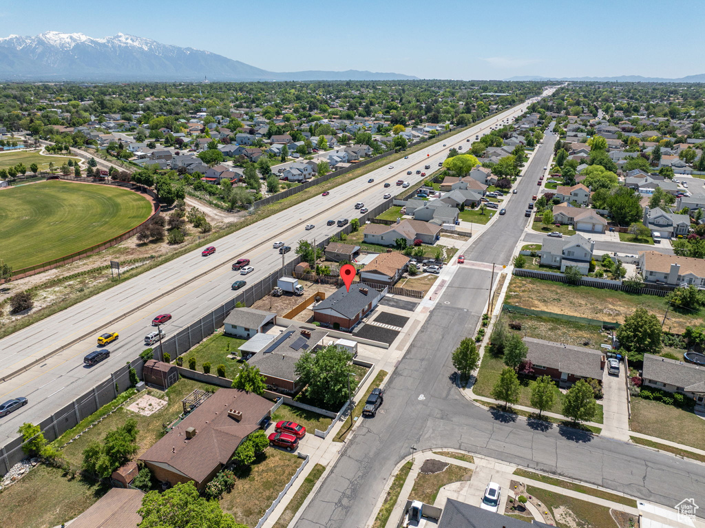 Aerial perspective of suburban area with a mountainous background and a major roadway