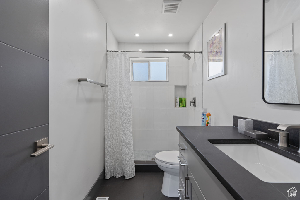Bathroom with toilet, vanity, a tile shower, tile patterned flooring, and recessed lighting