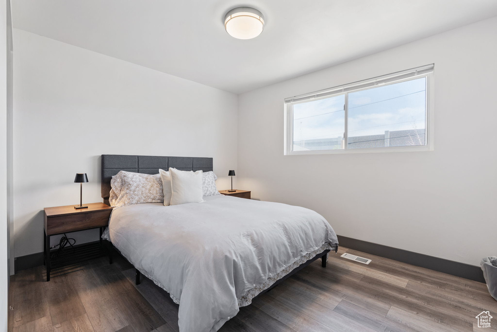 Bedroom with wood finished floors and baseboards