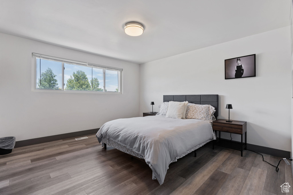 Bedroom with wood finished floors and baseboards