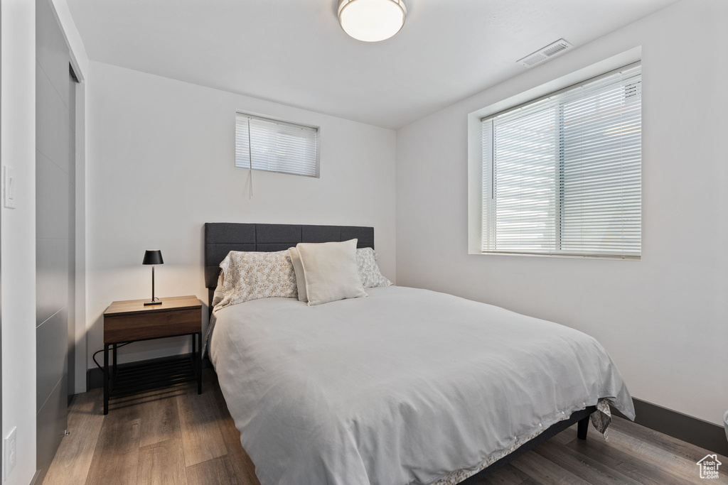 Bedroom with wood finished floors and a closet