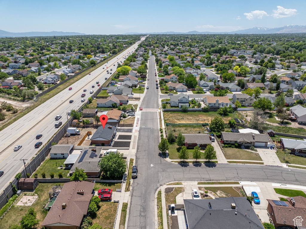 Aerial view of residential area featuring mountains and a major roadway