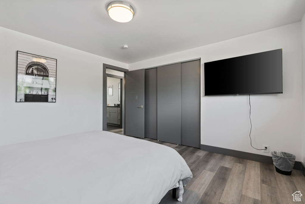 Bedroom with wood finished floors and a closet
