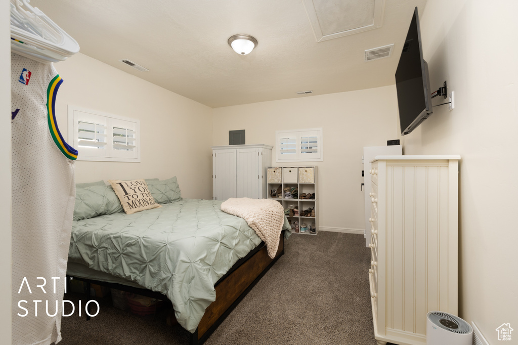 Bedroom featuring dark carpet and baseboards