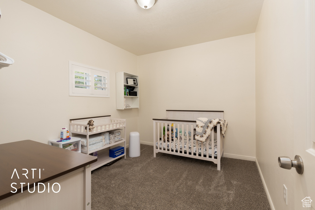Bedroom with carpet floors, baseboards, and a nursery area