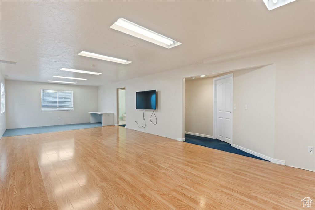 Spare room featuring a skylight and wood finished floors