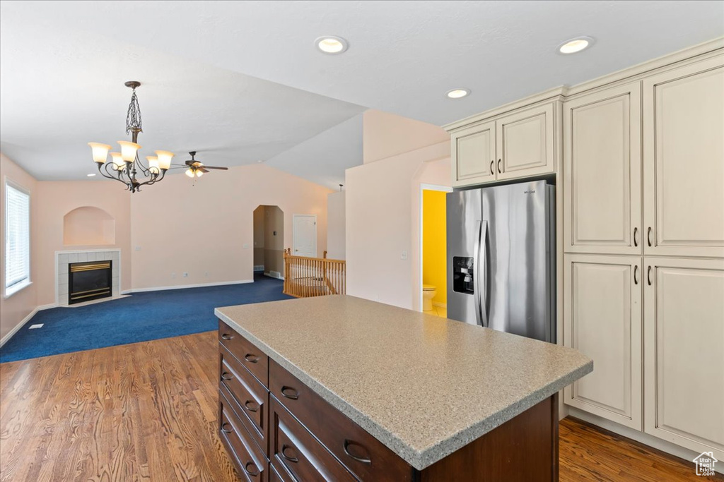 Kitchen featuring cream cabinetry, stainless steel refrigerator with ice dispenser, light countertops, a chandelier, and dark brown cabinetry