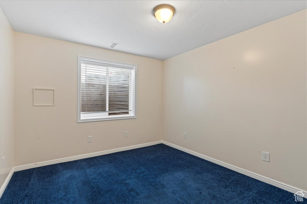 Unfurnished room with dark carpet and baseboards