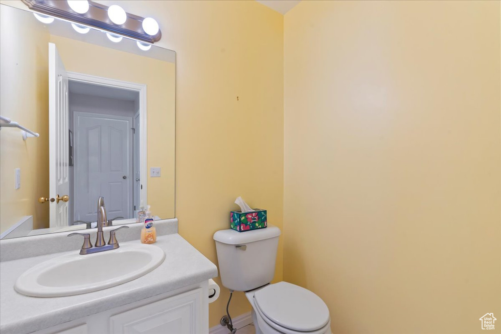 Half bath featuring toilet and vanity