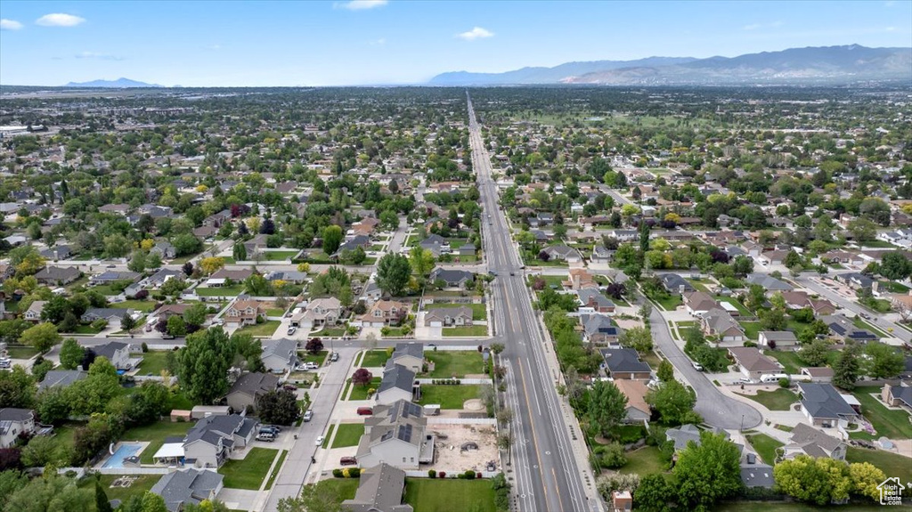 Aerial overview of property's location with a mountainous background, a main thoroughfare, and nearby suburban area