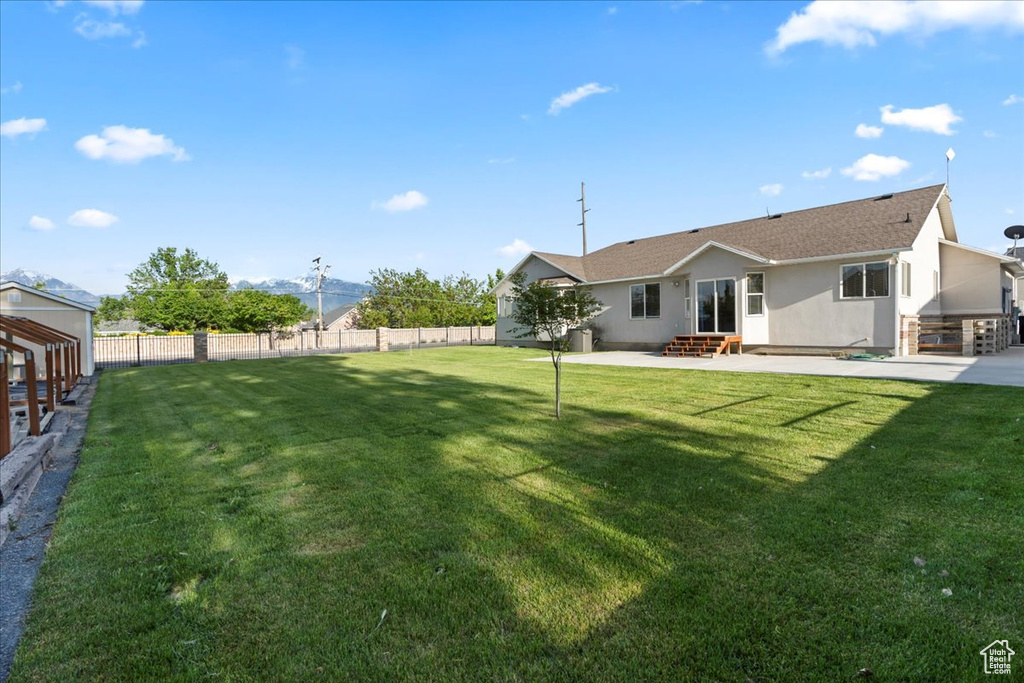 Back of house with entry steps, a patio area, stucco siding, and roof with shingles