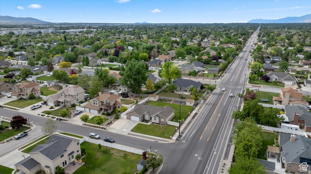 Aerial view of property and surrounding area with a mountain backdrop, nearby suburban area, and a major roadway