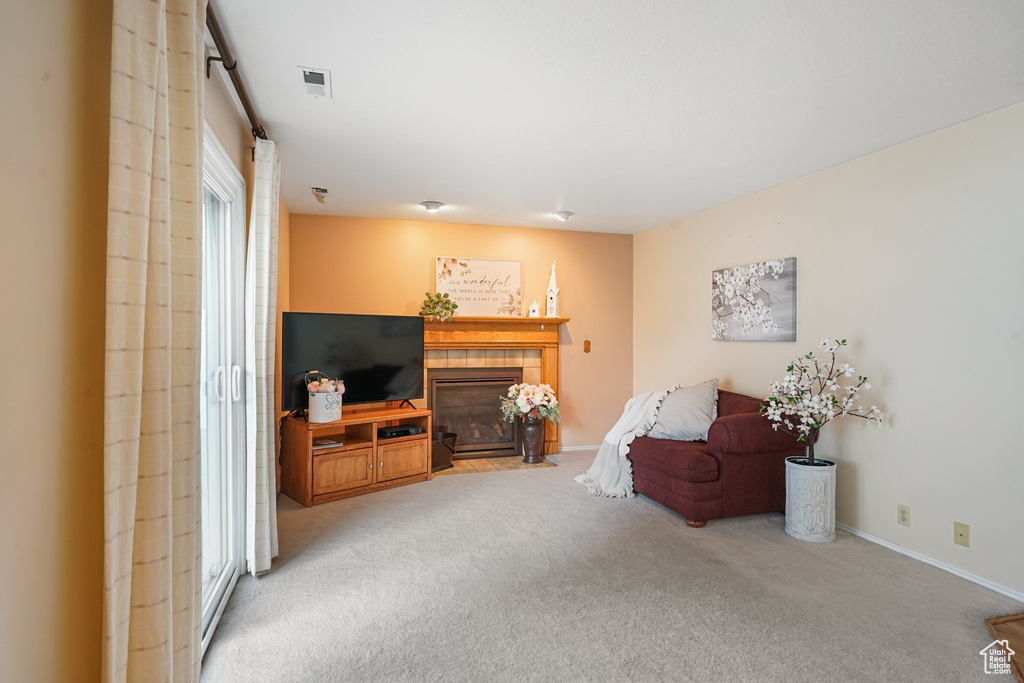Sitting room with carpet, a tile fireplace, and baseboards